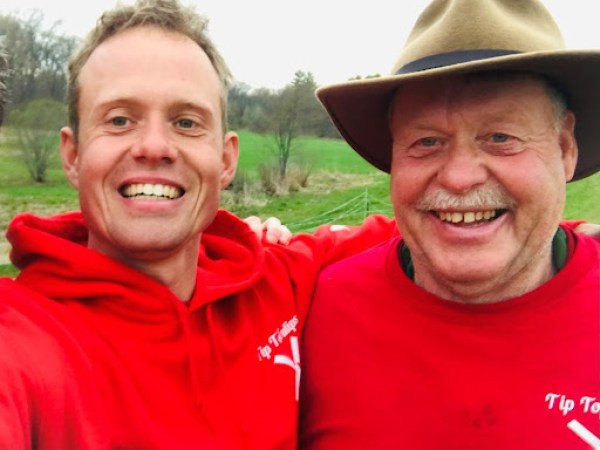 a man wearing a hat and smiling at the camera