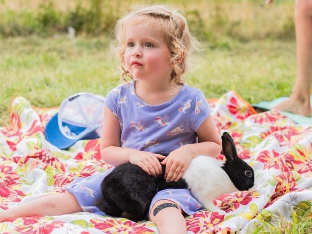 a little girl sitting on a bed