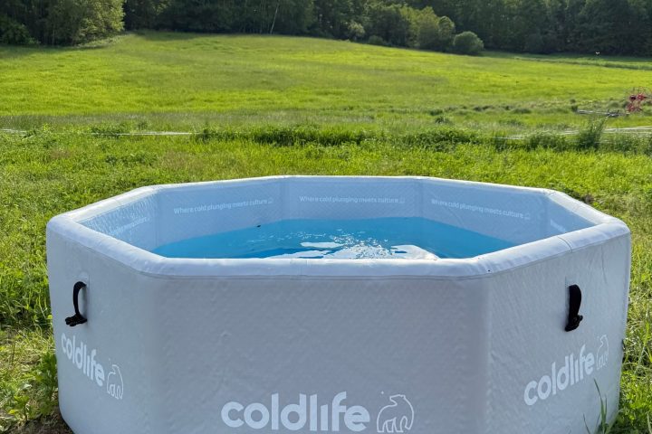 Hexagonal inflatable pool branded 'coldlife' in a grassy field with trees in the background.